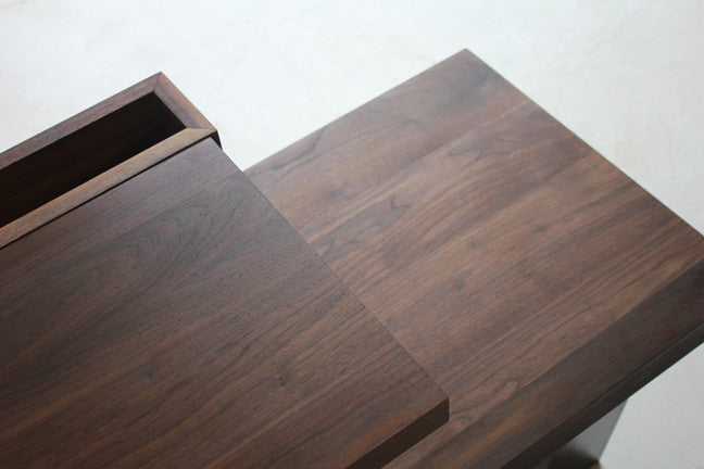Top-down close-up of the End Table's tiered walnut surfaces, showing the wood grain and recessed tray