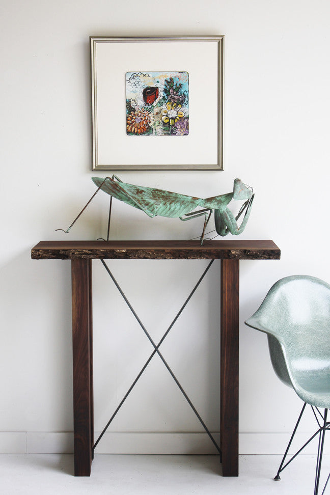 Craft Associates® Live Edge console in luxury mid century modern walnut, full room view beneath framed art and a modern lounge chair